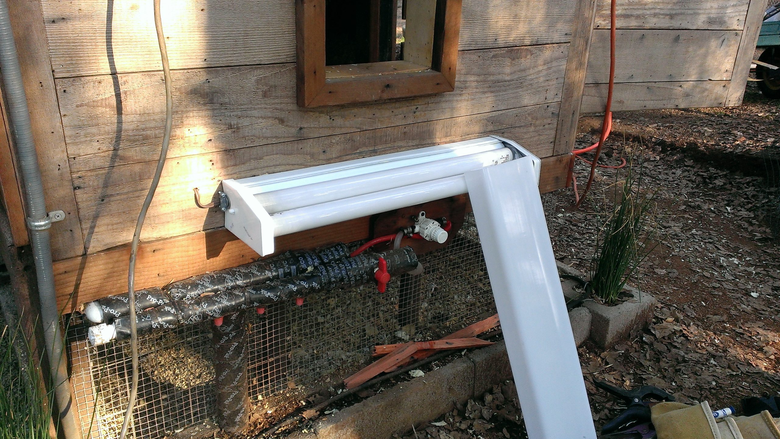 Chicken Coop Heater (shop light with cover off) - Exterior Pipe Protection (mounted under stairs and above wrapped pipe)